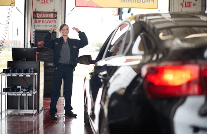 Mechanic guiding a car for emissions testing