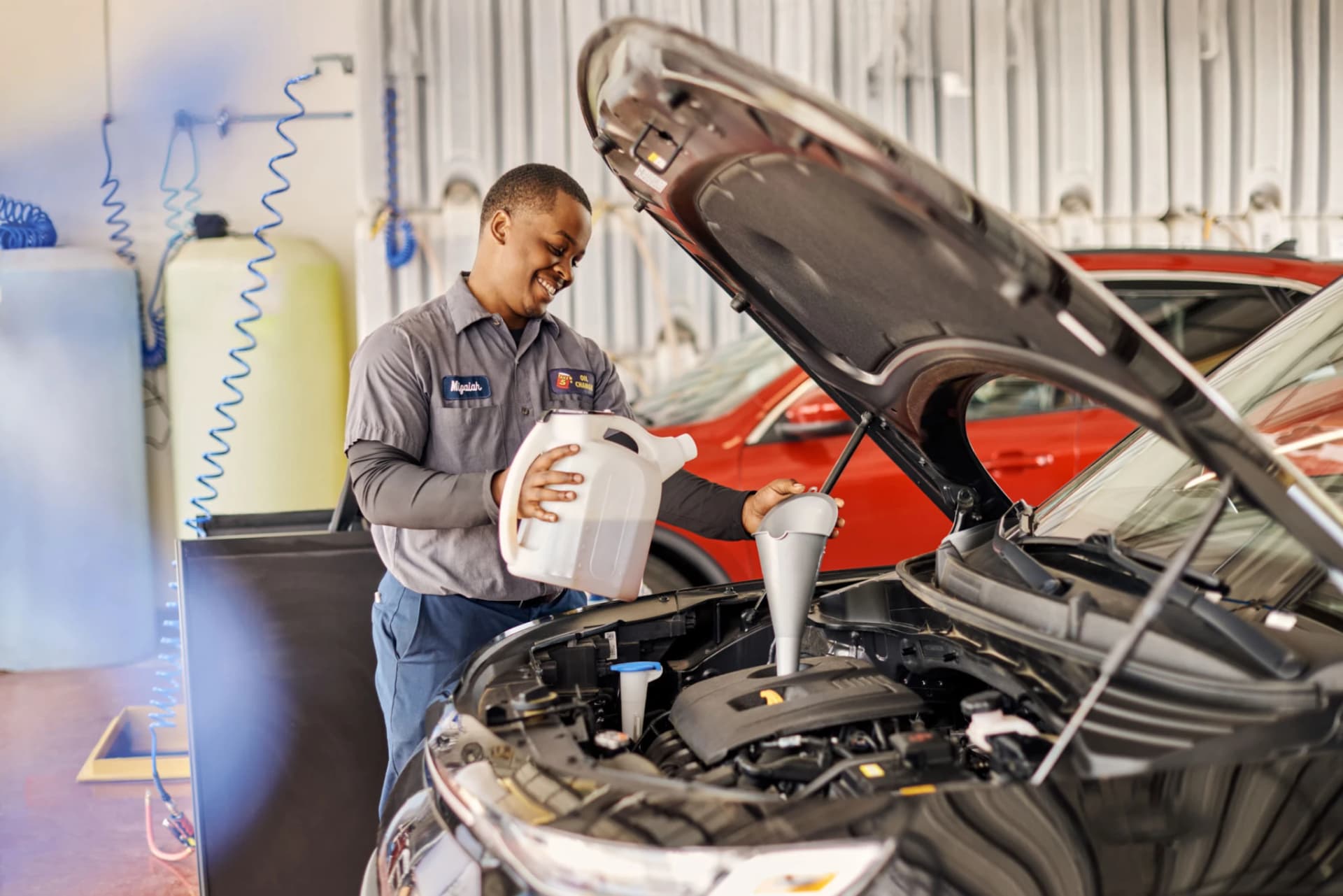 Mechanic conducting a diesel oil change under the car's hood